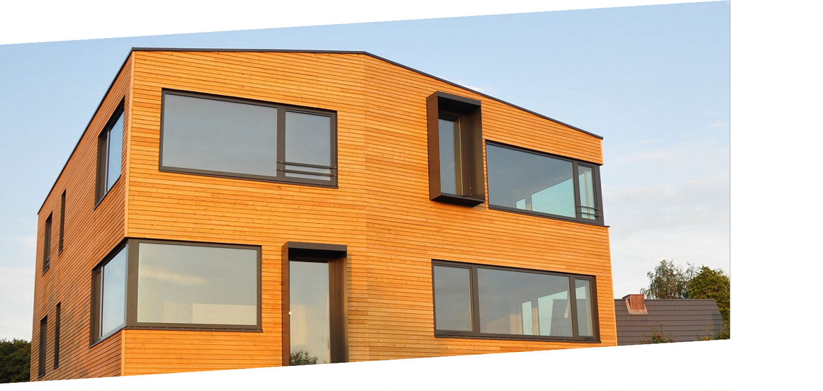 Ein modernes Architektenhaus mit verbautem Naturstoff Holz. Modernes Architektenhaus mit vielen Fenstern und Holzfassade.